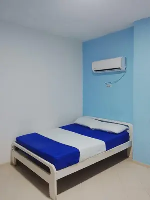 a bedroom with a bed with a blue wall at Hotel Palma Azul in Coveñitas