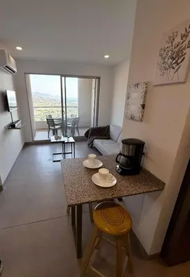 a kitchen and living room with a table and chairs at BRISA MARINA, Santa Marina Condominio in Santa Marta