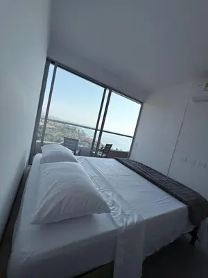 a large bed in a room with a large window at BRISA MARINA, Santa Marina Condominio in Santa Marta