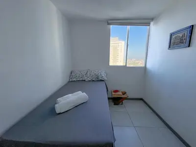 a bed in a room with a window at Acogedor Apto Cerca A La Playa WiFi Piscina AC in Cartagena de Indias