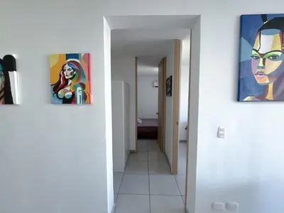 a hallway with three paintings on the walls at Acogedor Apto Cerca A La Playa WiFi Piscina AC in Cartagena de Indias