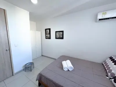 a bedroom with a bed with two white towels on it at Acogedor Apto Cerca A La Playa WiFi Piscina AC in Cartagena de Indias