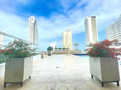 a balcony with two potted plants and buildings at Apartamento a pasos del mar y centro en Cartagena, piscina sauna & turco in Cartagena de Indias