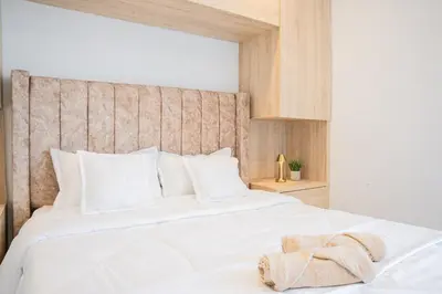 a bedroom with a white bed with a wooden headboard at Luxury apartment with ocean view 15th floor in Cartagena de Indias