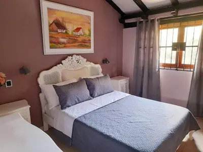 a bedroom with a bed and a painting on the wall at Habitación Luminosa Manga in Cartagena de Indias