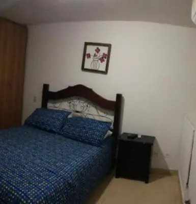 a bedroom with a bed and a picture on the wall at Cómoda habitación cerca de la via 40 Carnaval Barranquilla in Barranquilla