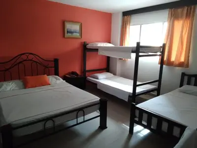 a room with three bunk beds and a window at hotel hispanoamericano in Barranquilla