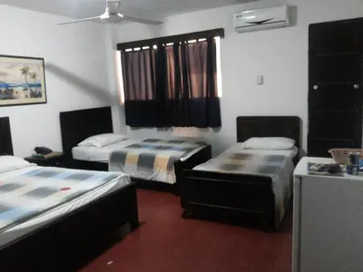 a room with two beds and a window in it at hotel hispanoamericano in Barranquilla