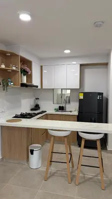 a kitchen with a table and two stools in it at Apartamento acogedor y tranquilo cerca del mar in Cartagena de Indias