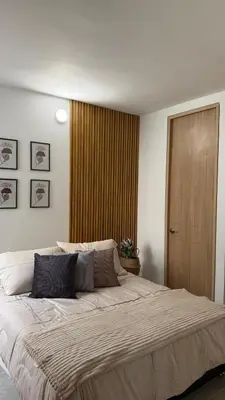 a bedroom with a large bed and a wooden door at Apartamento acogedor y tranquilo cerca del mar in Cartagena de Indias