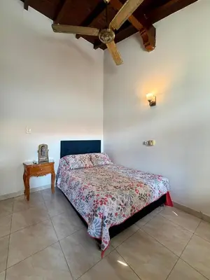a bedroom with a bed in a room with a table at Cozy Apartment Near Airport, Beaches & Old City in Cartagena de Indias