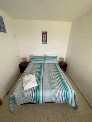 a bedroom with a bed with a striped comforter at Apartamento con la mejor ubicación y vista al mar in Cartagena de Indias