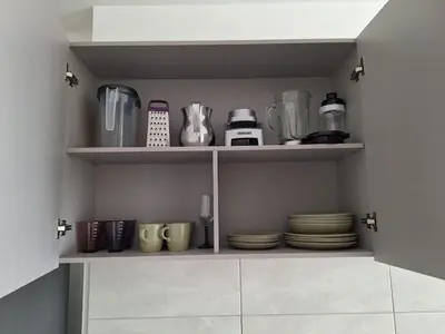 a cupboard with plates and utensils in a kitchen at Santa Marina Modern Loft Santa Marta in Santa Marta