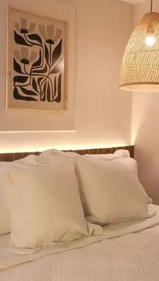 a bedroom with a bed with white sheets and a lamp at Margarita 93 in Barranquilla