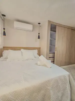 a large white bed in a room with a window at Margarita 93 in Barranquilla