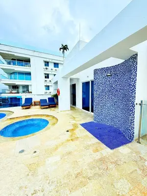 a pool with a blue tile wall and a building at Retiro del Caribe in Cartagena de Indias