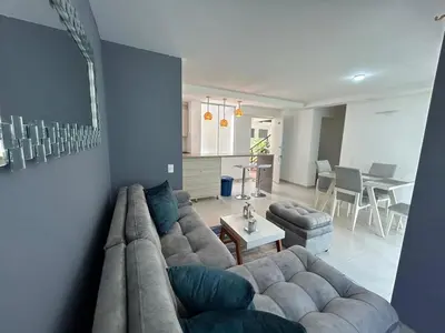 a living room with a large couch and a table at Serena Del Mar Apartment in Cartagena de Indias