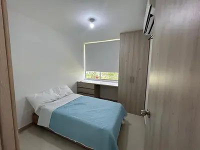 a small bedroom with a bed and a window at Serena Del Mar Apartment in Cartagena de Indias