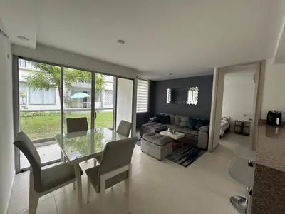 a living room with a glass table and a couch at Serena Del Mar Apartment in Cartagena de Indias