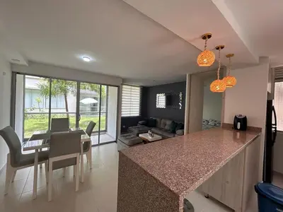 a kitchen and living room with a counter and a table at Serena Del Mar Apartment in Cartagena de Indias