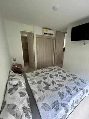 a bedroom with a bed and a tv on the wall at Serena Del Mar Apartment in Cartagena de Indias