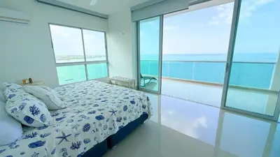 a bedroom with a bed with a view of the ocean at Magico Apartamento Frente al Mar 5 Habitaciones OS121 in Coveñitas