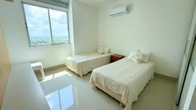 a white room with two beds and a window at Magico Apartamento Frente al Mar 5 Habitaciones OS121 in Coveñitas