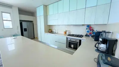 a kitchen with white cabinets and a stove top oven at Magico Apartamento Frente al Mar 5 Habitaciones OS121 in Coveñitas