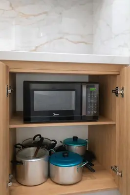 a kitchen with a microwave and two pots and pans at Apartamento para familias cerca de la playa y sitios turísticos in Cartagena de Indias