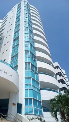 a tall building with a palm tree in front of it at Vive al estilo Cartagenero frente al mar y al lago in Cartagena de Indias