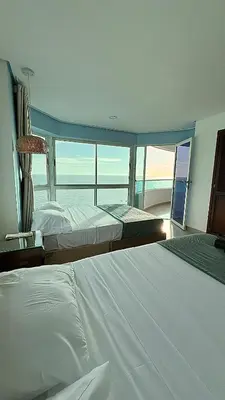 two beds in a bedroom with a view of the ocean at Vive Cartagena frente al mar y el lago in Cartagena de Indias
