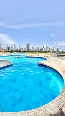 a pool with blue water with a city in the background at Vive Cartagena frente al mar y el lago in Cartagena de Indias