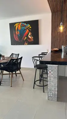 a dining room with chairs and a painting on the wall at Vive Cartagena frente al mar y el lago in Cartagena de Indias