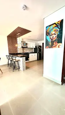 a kitchen and living room with a painting on the wall at Vive Cartagena magica frente al mar y lago in Cartagena de Indias