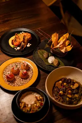 a wooden table with plates of food on it at Cuna 58 in Barranquilla