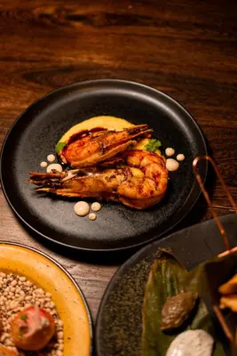 a plate of food with shrimp on a table at Cuna 58 in Barranquilla