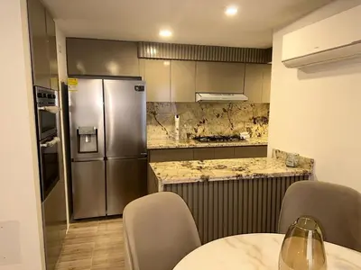 a kitchen with a refrigerator and a table and chairs at Luxury apartment in Barranquilla