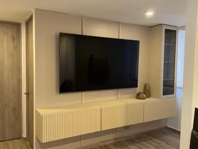 a living room with a large television on a wall at Luxury apartment in Barranquilla