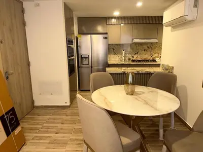 a dining room with a table and chairs and a kitchen at Luxury apartment in Barranquilla