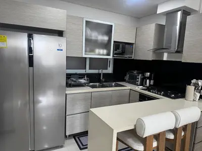 a kitchen with a stainless steel refrigerator and a table at NEW Premium 1BR Apartment in the Best Area in Barranquilla