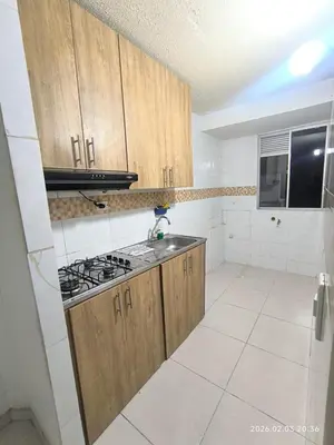 a kitchen with wooden cabinets and a stove top oven at Apartamento acogedor y fresco cerca al norte de barranquilla in Barranquilla