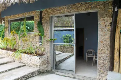 a glass door to a building with a stone wall at Casaroca in Turbaco