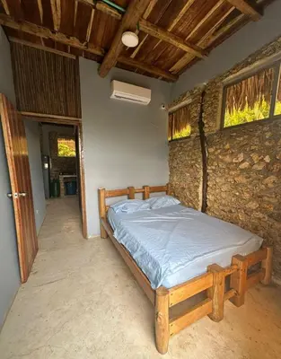 a bed in a room with a stone wall at Casaroca in Turbaco