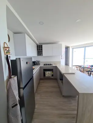 a kitchen with white cabinets and a stainless steel refrigerator at Oceani Tower Cielo Mar Apartment in Cartagena de Indias