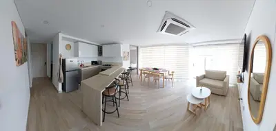 a kitchen and living room with a table and chairs at Oceani Tower Cielo Mar Apartment in Cartagena de Indias