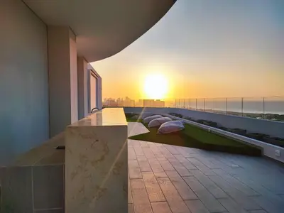 a balcony with a view of the sunset on a building at Oceani Tower Cielo Mar Apartment in Cartagena de Indias