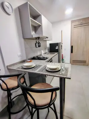 a kitchen with two chairs and a table with plates on it at Apartamento de lujo en Santa Marta in Santa Marta