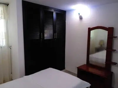 a bedroom with a black door and a mirror at Ideal house for Carnival in Barranquilla