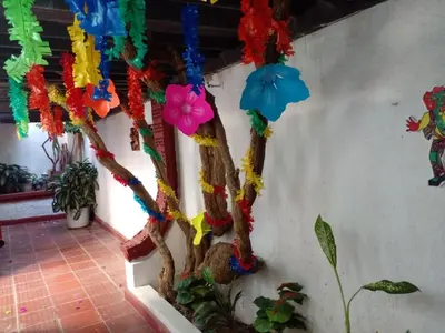a tree decorated with colorful streamers and flowers at Ideal house for Carnival in Barranquilla