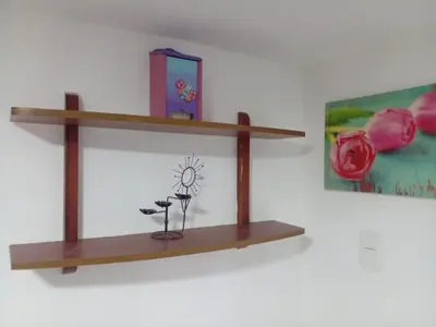 a shelf on a wall with flowers and a picture at Ideal house for Carnival in Barranquilla